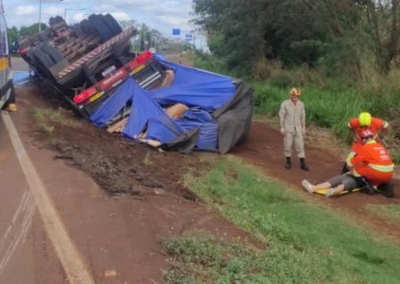 Caminhoneiro fica ferido após carreta com madeira tombar na BR-163>